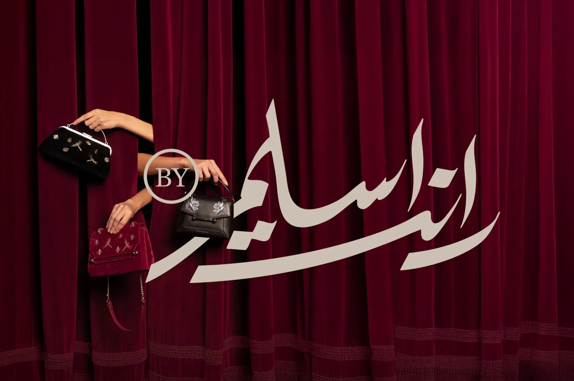 The Randa Selim calligraphic logo in front of a red curtain