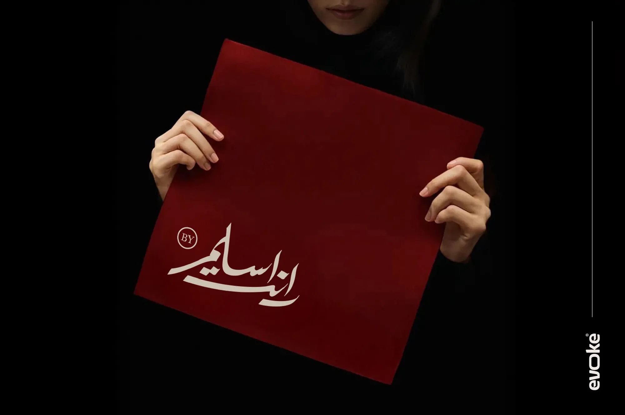 Hands holding a red card with the Randa Selim calligraphy